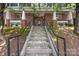 Building entrance with concrete steps, black railings, and brick facade at 1556 Walnut View Dr, Charlotte, NC 28208