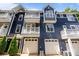 Exterior view of townhomes showing a balcony, windows, and garage doors at 1556 Walnut View Dr, Charlotte, NC 28208