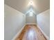 Finished attic space with wood flooring, neutral paint, and window offering versatile options at 2021 Charlotte Dr, Charlotte, NC 28203