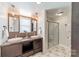 Bright bathroom with dual sinks, granite countertop, mosaic backsplash, and a glass-enclosed shower at 2021 Charlotte Dr, Charlotte, NC 28203
