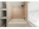 Tiled bathroom with a bright window and a combined shower and tub, perfect for relaxing and bathing at 2021 Charlotte Dr, Charlotte, NC 28203