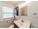 Bathroom featuring a single sink vanity, dark cabinetry, window and neutral color scheme at 2021 Charlotte Dr, Charlotte, NC 28203