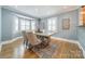 Bright dining room with a large window, hardwood floors, and a modern table set for Gathering meals at 2021 Charlotte Dr, Charlotte, NC 28203
