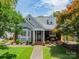 Charming gray and brick home with manicured lawn and inviting front porch with rocking chairs at 2021 Charlotte Dr, Charlotte, NC 28203