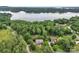 Aerial view of a brick home surrounded by lush greenery and mature trees near the shores of a large lake at 2030 Fasana Rd, York, SC 29745