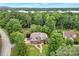 Aerial view of a brick home surrounded by lush greenery, mature trees, and meticulous landscaping at 2030 Fasana Rd, York, SC 29745