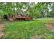 Expansive backyard with lush lawn, wooden deck, beautiful landscaping, and mature trees providing ample shade at 2030 Fasana Rd, York, SC 29745