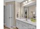 Well-lit bathroom with white cabinets, mirror, and a view into the adjacent toilet and shower at 2030 Fasana Rd, York, SC 29745