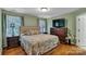 Cozy bedroom featuring hardwood floors, a queen-sized bed, and a large TV on a dresser at 2030 Fasana Rd, York, SC 29745