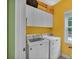 Bright laundry room with white washer and dryer and upper cabinets for storage at 2030 Fasana Rd, York, SC 29745