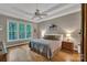 Serene bedroom with a tray ceiling, large window, hardwood floors, and a comfortable bed with decorative pillows at 2030 Fasana Rd, York, SC 29745