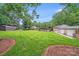 Expansive backyard featuring well-manicured lawn, mature trees, a pool, outbuildings, and patio at 211 Drive Inn Rd, Locust, NC 28097