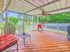 Inviting covered deck featuring wood flooring, a ceiling fan, and comfortable outdoor seating at 211 Drive Inn Rd, Locust, NC 28097
