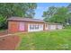 Exterior view showcasing the multiple garages of the property, with lawn and mature trees at 211 Drive Inn Rd, Locust, NC 28097