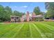 Beautiful brick home with a spacious lawn, covered patio, and additional covered parking at 211 Drive Inn Rd, Locust, NC 28097