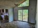 Dining area with sliding doors leading to a deck, featuring a view of the wooded backyard at 211 Putnam St, Shelby, NC 28152