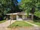 Exterior view of house featuring an overgrown lawn and brown shutters at 211 Putnam St, Shelby, NC 28152