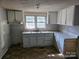 Kitchen featuring upper and lower white cabinets with a double sink, and a window at 211 Putnam St, Shelby, NC 28152