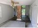 Living room featuring a brick column, sliding glass doors to deck, and a unique ceiling fan at 211 Putnam St, Shelby, NC 28152