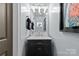 Chic powder room featuring dark vanity, marble countertop, vessel sink, and modern decor at 224 Wendover Heights Cir, Charlotte, NC 28211