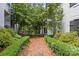 Lush landscaping and a brick path lead to the home's entrance, surrounded by mature trees and greenery at 224 Wendover Heights Cir, Charlotte, NC 28211