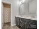 Stylish bathroom with a double sink vanity, dark wood cabinets, modern fixtures, and wood-look tile flooring at 2593 Las Brisas Ln, Denver, NC 28037