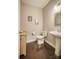 Cozy powder room featuring a pedestal sink, toilet, decorative art, and beautiful dark wood floors at 2593 Las Brisas Ln, Denver, NC 28037