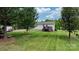 Well-maintained backyard featuring a wooden deck, lush lawn, mature trees, and shed at 2843 Hopewell Church Rd, Sherrills Ford, NC 28673