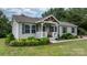 Charming single-story home featuring a covered porch, gray siding, black shutters, and manicured landscaping at 2843 Hopewell Church Rd, Sherrills Ford, NC 28673