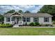 Charming single-story home featuring a covered porch, gray siding, black shutters, and colorful landscaping at 2843 Hopewell Church Rd, Sherrills Ford, NC 28673