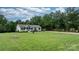 Well-maintained home surrounded by lush greenery, a spacious lawn, and mature trees on a sunny day at 2843 Hopewell Church Rd, Sherrills Ford, NC 28673
