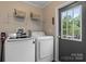 Convenient laundry room with modern washer and dryer, wire shelving, and easy outdoor access at 2843 Hopewell Church Rd, Sherrills Ford, NC 28673