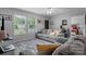 Cozy living room with neutral colors, a plush gray sofa, bright windows, and a glimpse into the bedroom at 2843 Hopewell Church Rd, Sherrills Ford, NC 28673
