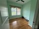 Bedroom with hardwood floors, ceiling fan, window with blinds, and light green walls at 28835 Hartsell Rd, Albemarle, NC 28001