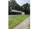 Large carport with a gravel driveway and lush green lawn surroundings at 28835 Hartsell Rd, Albemarle, NC 28001