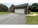 Attached garage featuring a white door and gravel driveway at 28835 Hartsell Rd, Albemarle, NC 28001
