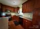 Well-appointed kitchen with dark wood cabinets, granite countertops, and stainless steel appliances at 28835 Hartsell Rd, Albemarle, NC 28001
