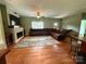 Inviting living room with a brick fireplace, hardwood floors, and a leather couch at 28835 Hartsell Rd, Albemarle, NC 28001