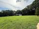 Lush green yard with mature trees and a small building in the distance at 28835 Hartsell Rd, Albemarle, NC 28001