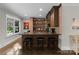 Finished basement bar with brick accents, dark wood cabinets, and recessed lighting at 2941 Forest Park Dr, Charlotte, NC 28209