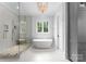 Bright bathroom with a soaking tub under the window and a large glass shower with river rock floor at 2941 Forest Park Dr, Charlotte, NC 28209