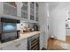 View of Butler's pantry with beverage center, ice maker, white cabinetry, and marble countertop at 2941 Forest Park Dr, Charlotte, NC 28209