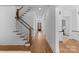 Bright foyer featuring hardwood floors, a staircase with white risers, and hallway with views to back at 2941 Forest Park Dr, Charlotte, NC 28209