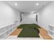 Basement Golf simulator room with green turf, white shelving, and recessed lights at 2941 Forest Park Dr, Charlotte, NC 28209