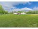 Expansive backyard with a well-maintained lawn, featuring a detached garage and wooded views at 326 Teeter Rd, Mooresville, NC 28115