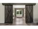 Bathroom viewed through rustic barn doors showcasing soaking tub and a large window with natural light at 326 Teeter Rd, Mooresville, NC 28115