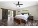 Bedroom featuring wood-look floors, barn door access to bathroom, and natural light, creating a peaceful retreat at 326 Teeter Rd, Mooresville, NC 28115