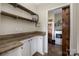 Functional laundry room with wooden countertop, open shelving, a washing machine, and a sliding barn door at 326 Teeter Rd, Mooresville, NC 28115