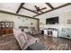 Cozy living room featuring a wooden ceiling beam, a large flat-screen TV, comfortable seating, and a rustic-chic aesthetic at 326 Teeter Rd, Mooresville, NC 28115
