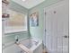 A soaking tub sits beneath a bright window in this bathroom at 4502 Magnolia Ridge Dr, Waxhaw, NC 28173